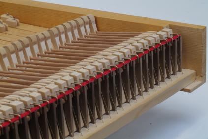 Rückseite der Klaviatur mit Ausschnitten, in der die Auslöser-Leiste liegt